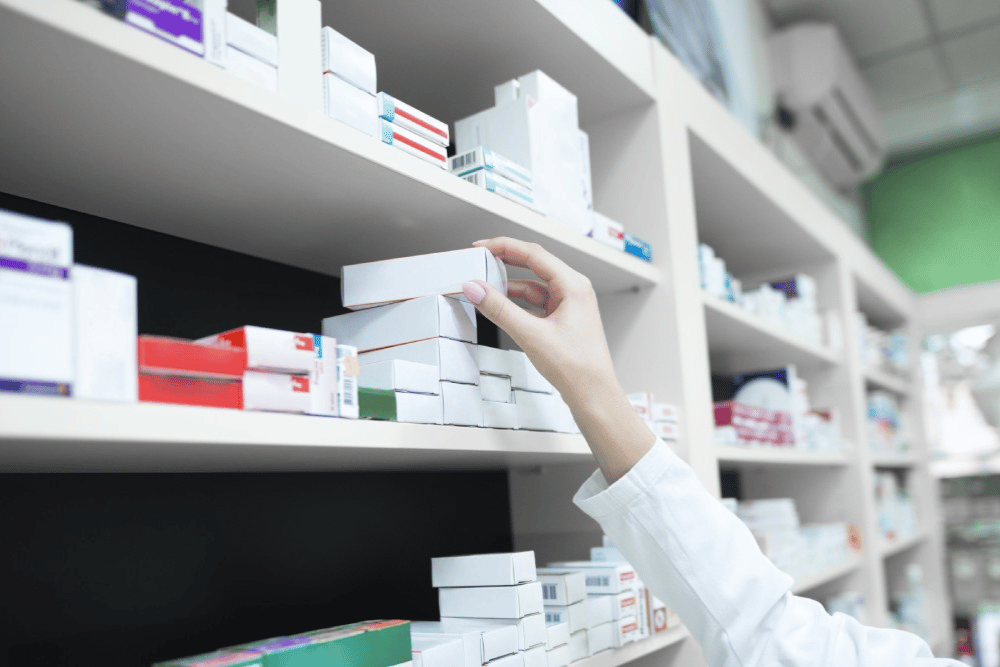 pharmacist taking medicines from shelves